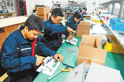 員工在生產車間裝配工業產品